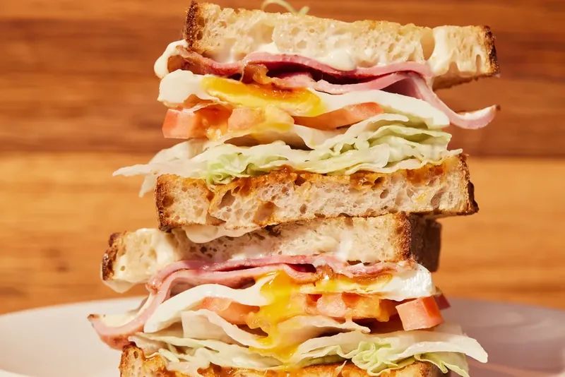 A stacked Beggs & Acon egg and ham sandwich