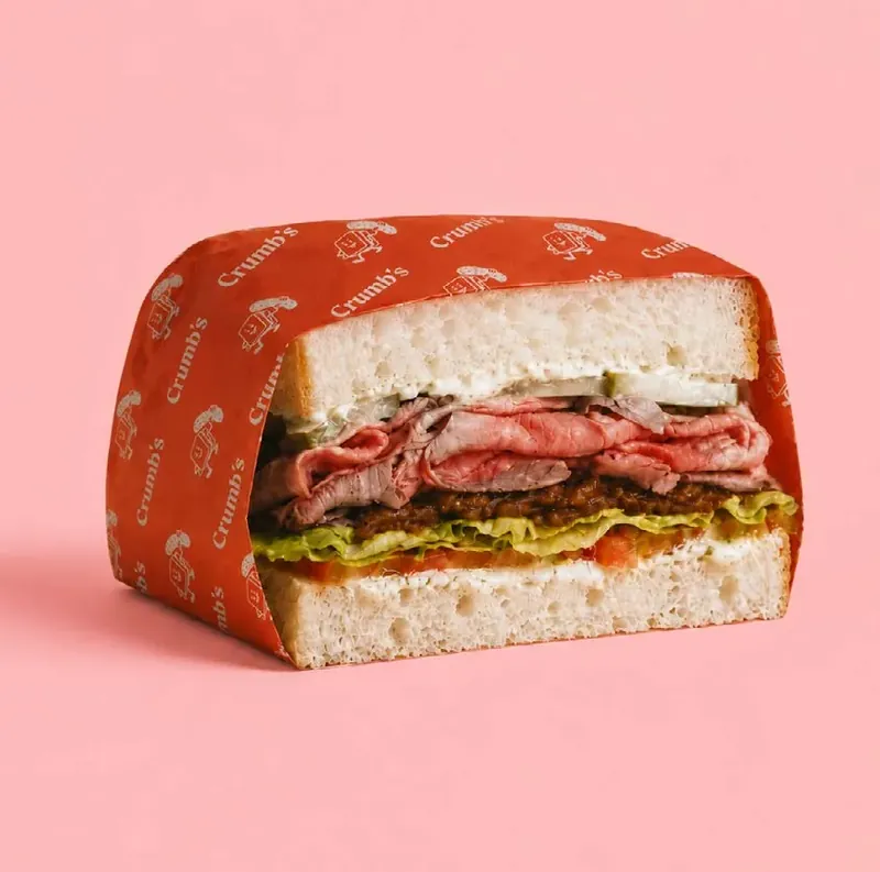 A Crumb's roast beef sandwich in a red Crumb's wrapper